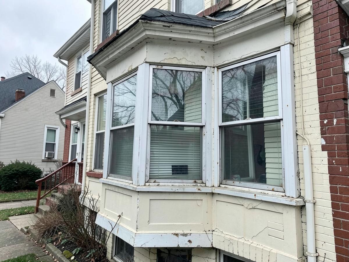 Weathered bay window with cracked paint